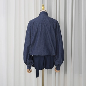 Rear view of dark blue denim two-piece set with puffed sleeve shirt and shorts on mannequin