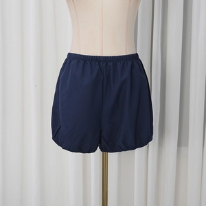 Detailed view of high-waist dark blue puffy shorts with elastic band and leg cuffs