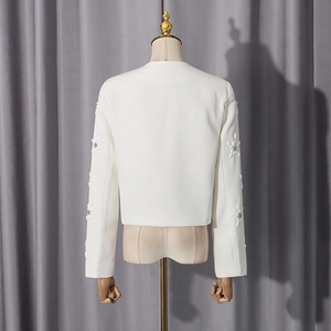 Detailed back view of white blazer with 3D floral accents and rhinestones on sleeves