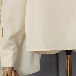 Close-up of beige shirt cuffs with single-needle stitching and crisp square hem detail