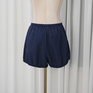 Detail view of navy blue bloomers featuring elastic pleated waist and ruffled leg openings