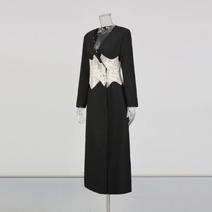 Gros plan d'un manteau noir élégant avec détail en dentelle blanche à la taille