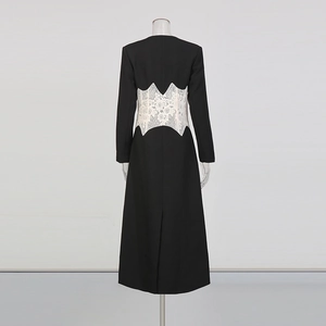 Vue arrière d'une robe longue noire avec patchwork de dentelle blanche et fente