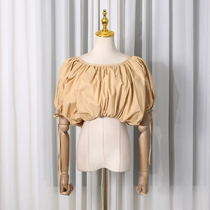 Detail of khaki puff sleeve crop top featuring pleats and adjustable drawstring cuffs
