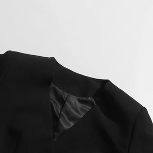 Détail du col d'un manteau noir avec tissu mat et doublure en satin soyeux