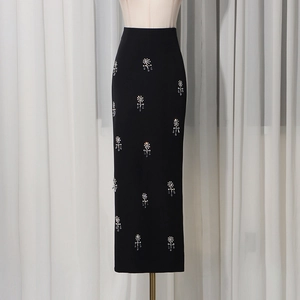Close-up of black high-waisted maxi skirt featuring crystal rhinestone tassel detailing
