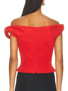 Top rosso aderente con spalle scoperte e cerniera posteriore in studio fotografico
