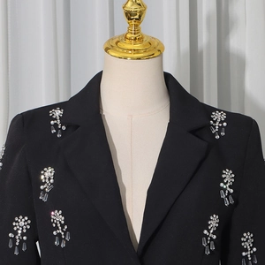 Detail of floral rhinestones and teardrop crystals on a black women's blazer lapel