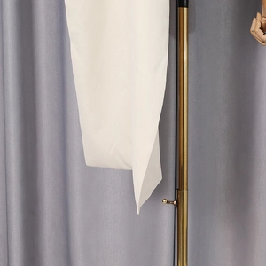 Detail of white woven fabric texture with decorative gold metal ring on stylish blazer