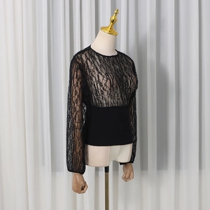 Detail of the black lace patchwork long sleeve top with slim fit bodice and sheer texture