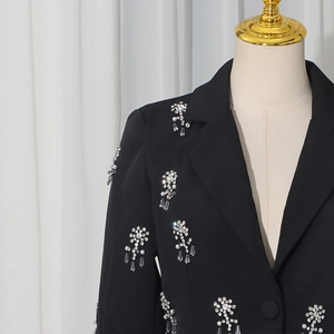 Detail of elegant black blazer featuring luxury 3D floral rhinestone and pearl embroidery