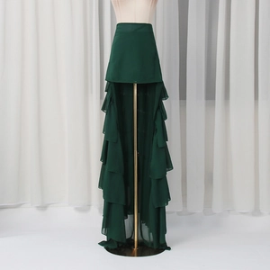 Detail of high-low dark green skirt featuring layered ruffles and sheer chiffon fabric