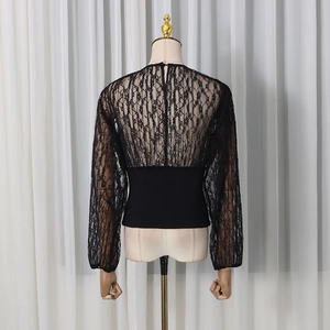 Close-up of elegant black lace patchwork top with floral cutouts and button back detail