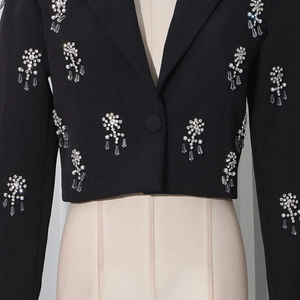 Detail of black blazer with hand-sewn rhinestones and beads on high-quality fabric