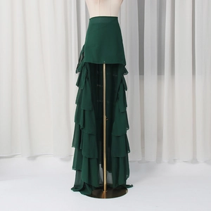 Detail of multi-layered dark green ruffled skirt showing layered chiffon texture and flowy hem
