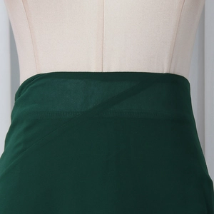Detail of dark green layered ruffles and textured chiffon fabric on a bodycon skirt