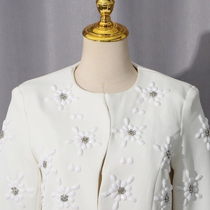 Detail of white round neck blazer with 3D floral beadwork and sparkling center rhinestones