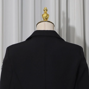 Detail of black blazer back with silver beaded tassel fringe on shoulders