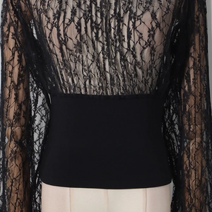 Close-up of black floral lace fabric and high-waist slimming design on women's top