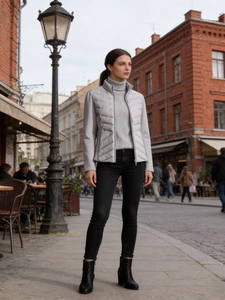 Slim fit light grey quilted vest paired with black jeans and boots on a classic street