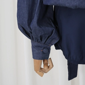 Detailed view of vintage dark blue puff sleeve with fabric button and elastic cuff