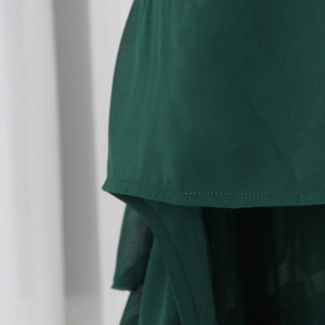 Detail of dark green chiffon skirt showing double-layered hem and precise stitching
