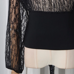 Detail of black lace long sleeve top with floral patterns and elastic waist feature