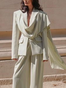 Chic cream-colored blazer suit with metal ring accents and elegant draped lapel design