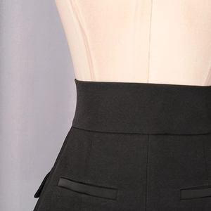 Detailed view of black high-waisted A-line skirt featuring professional welt pocket detail