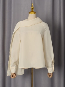 Elegant off-white long sleeve blouse with asymmetric draped shawl collar on a mannequin