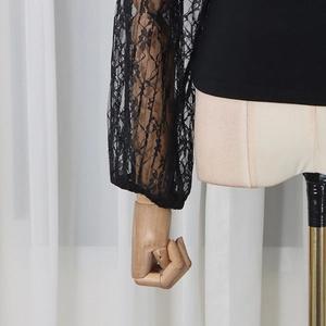Detailed close-up of long sleeve top with black floral lace stitching on sleeves