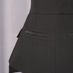 Detail view of black A-line skirt featuring decorative pockets and textured woven fabric