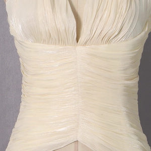 Détail du tissu en satin champagne avec une texture plissée élégante et décolleté en V