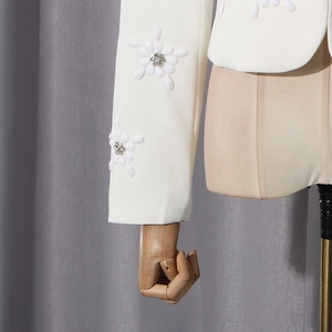 Detail of white blazer featuring 3D floral beaded embroidery with silver crystals on sleeve