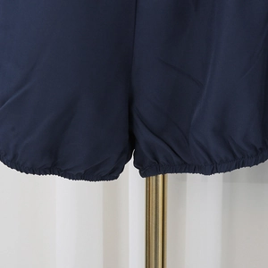 Detail of navy blue shorts featuring elasticated hems and high-quality pleated fabric texture