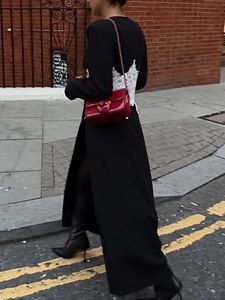 Manteau long élégant noir avec dentelle blanche au dos et sac à main rouge