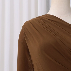 Nahaufnahme der asymmetrischen Falten auf braunem Netzstoff dieses schmalen Jumpsuits