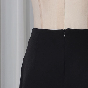 Detailed view of the invisible zipper closure on high-waist black formal trousers for women