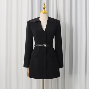 Detail of slim fit black blazer featuring a stylish metal buckle waist belt and lapel