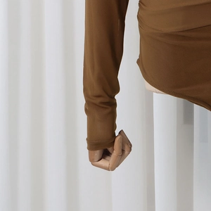 Detail der braunen Mesh-Ärmel zeigt Stofftextur und Manschette an einem Schaufensterpuppenarm
