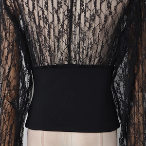 Detail of black lace patchwork top showing hollow floral lace sleeves and slim waist design