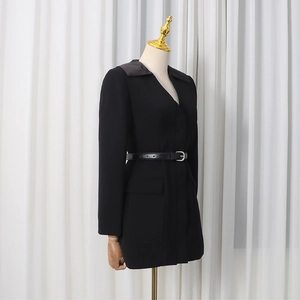 Close-up of contrast satin lapel and slim buckled belt on black tailored blazer dress