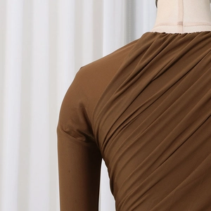 Detail der gerafften Textur und asymmetrischen Drapierung am braunen Damen-Body