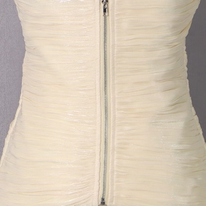Détail de tissu satiné crème avec plis horizontaux et fermeture à glissière en métal argenté