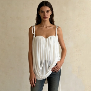 Detail of white pleated camisole with thin straps and elegant silk-like texture fabric