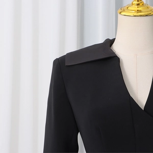 Detail of a chic black blazer featuring a V-neckline and overlapping square collar design