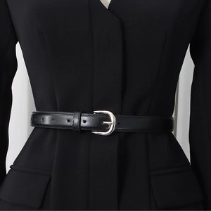 Close-up of black leather slim waist belt with silver metal horseshoe buckle on blazer