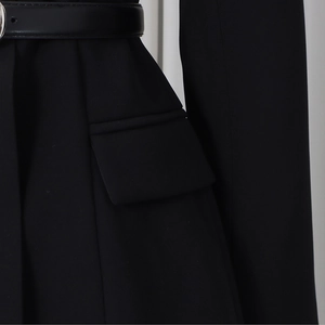 Detail of black blazer with slim leather belt and silver buckle and flap pocket