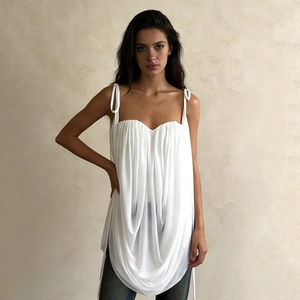 Detail of white pleated camisole with U-shaped draping and bow shoulder straps