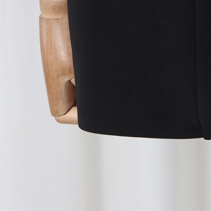 Detailed macro view of the premium black suit fabric texture and smooth hem finishing